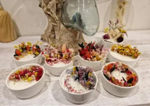 Plusieurs bougies fleuries sur une table réalisées pendant un atelier du Club des Simone