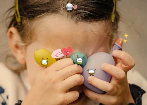 Enfant qui se cache les yeux avec des balles anti stress